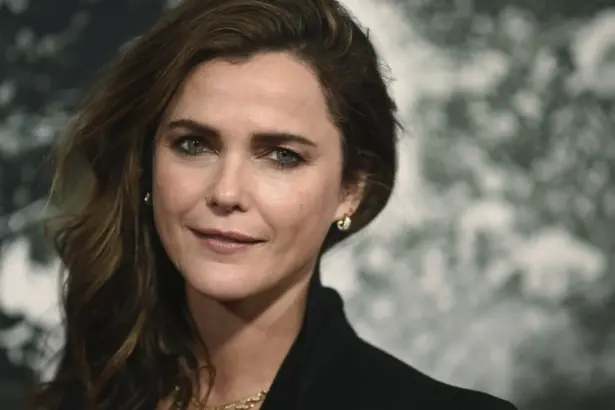 Keri Russell posing on the red carpet in a stylish black gown, highlighting her iconic curly hairstyle.
