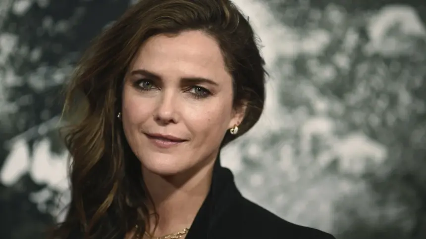 Keri Russell posing on the red carpet in a stylish black gown, highlighting her iconic curly hairstyle.