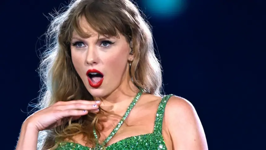 Portrait of Taylor Swift performing on stage during her Eras Tour, wearing a sparkling bodysuit and holding a microphone.