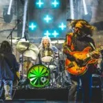 A vibrant collage featuring Thorn-Magazine Blog Band performing live, with colorful stage lighting, musical instruments, and a zine with bold text and artwork.